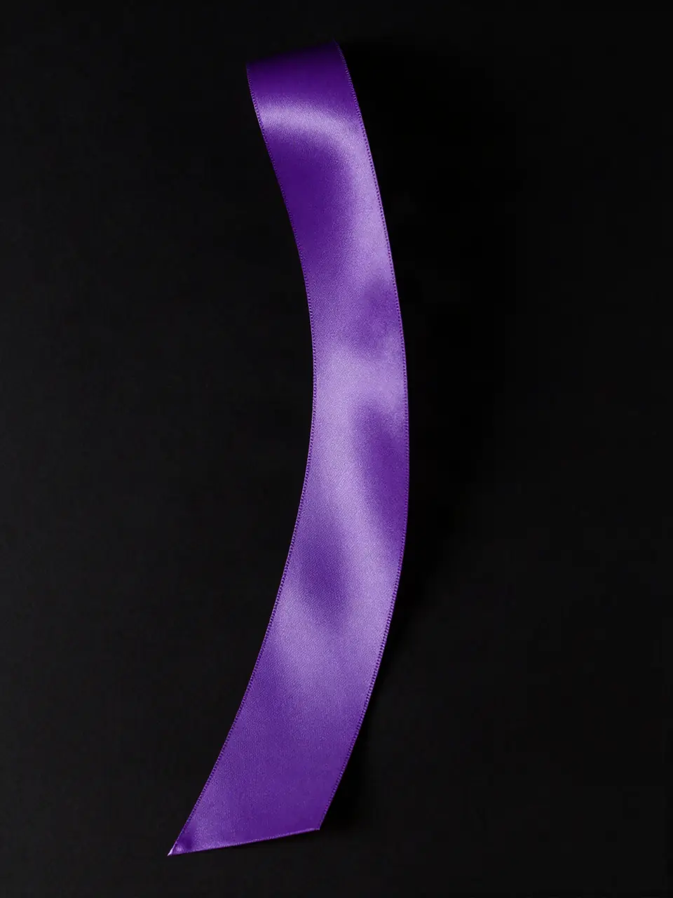 A curved violet satin ribbon on a black background