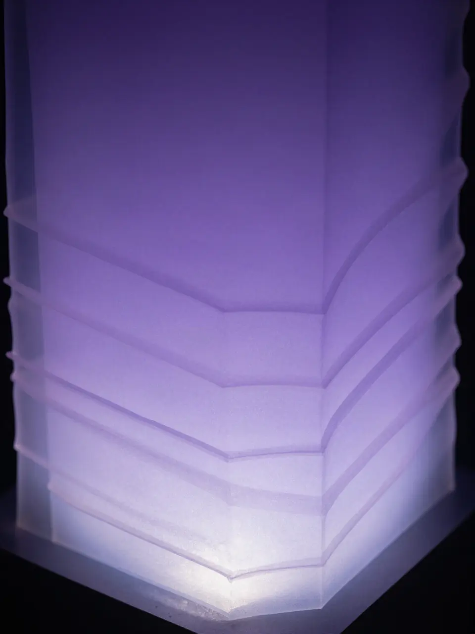 Stacked translucent layers lit from below with a soft violet glow