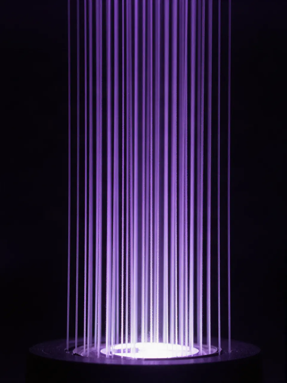 Vertical violet light strands rising from a glowing disc